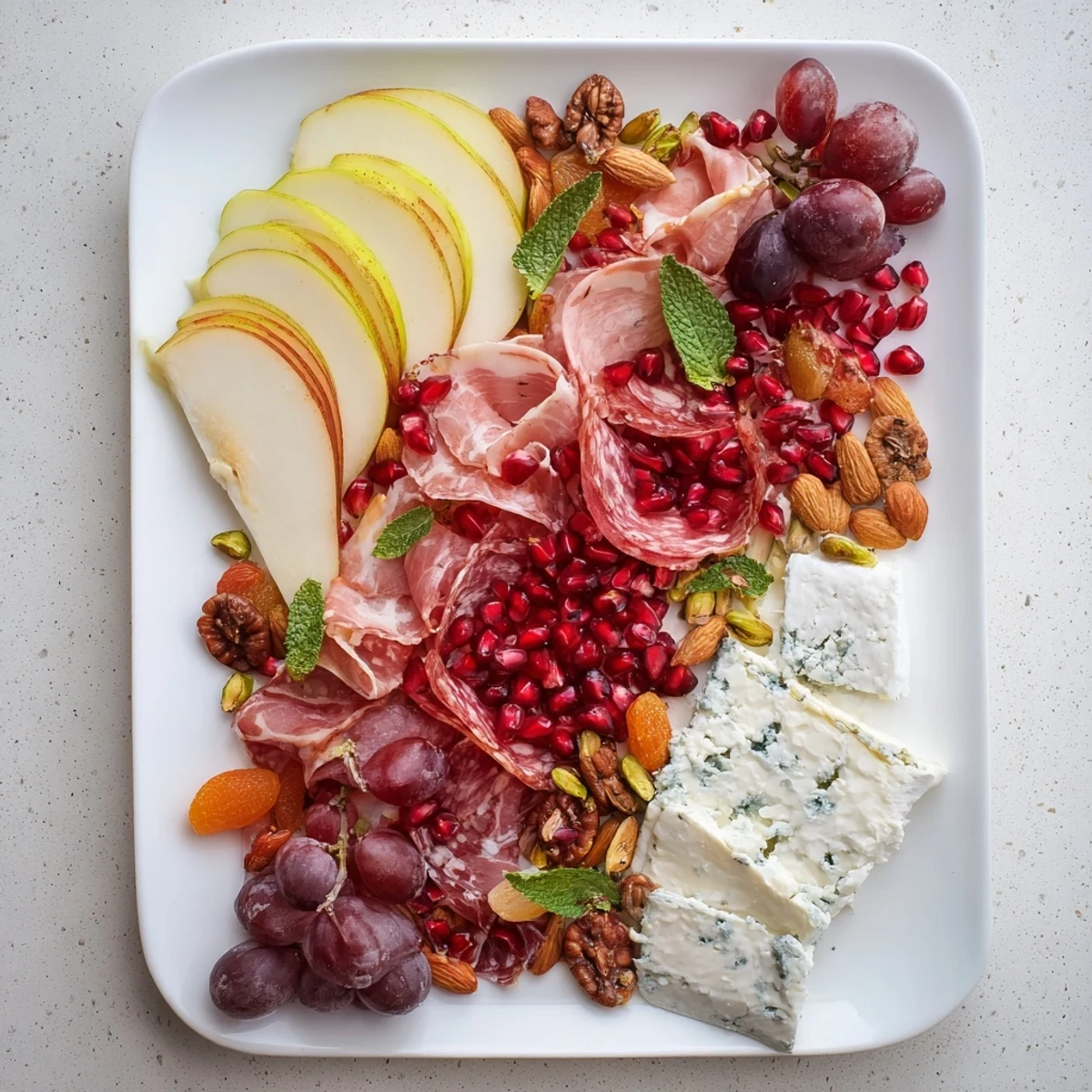Pomegranate Jewel Cascade cheese board, a colorful appetizer, showcases jewel-like pomegranate seeds and fresh fruit.