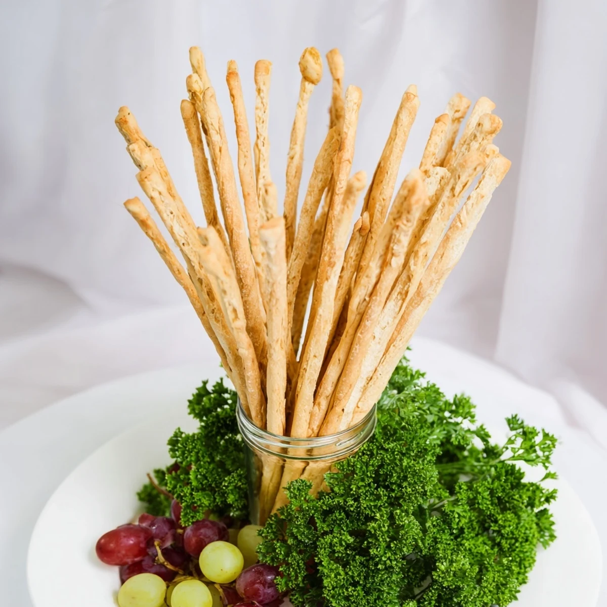 A visually stunning photo of The Vertical Forest, showing breadsticks, grapes, and verdant parsley.