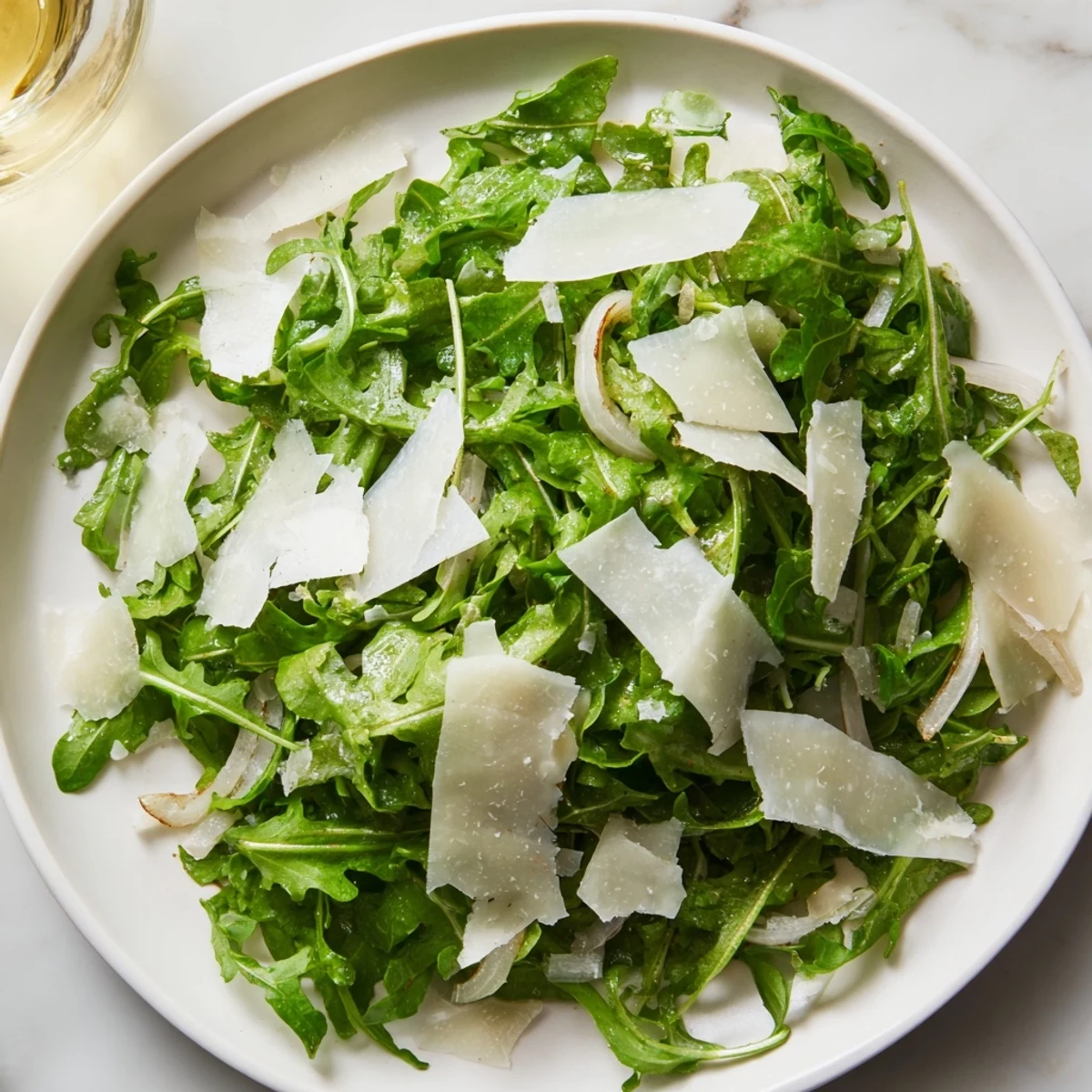A refreshing bowl of arugula salad, the recipe includes a simple, zesty lemon vinaigrette.