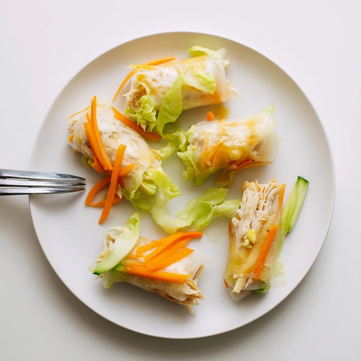 A close-up of Garlicky Pulled Chicken Wraps with golden rice paper and aromatic garlic-butter sauce.