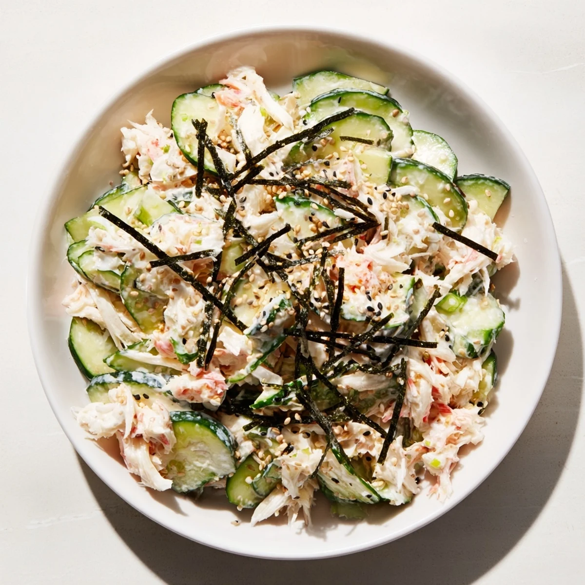 Chilled California Roll Cucumber Salad featuring tender imitation crab, creamy dressing, and crunchy sesame seeds, perfect for summer gatherings.