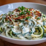 Low-carb zucchini noodles tossed in a velvety cottage cheese Alfredo sauce, offering a protein-rich twist on classic comfort food.  