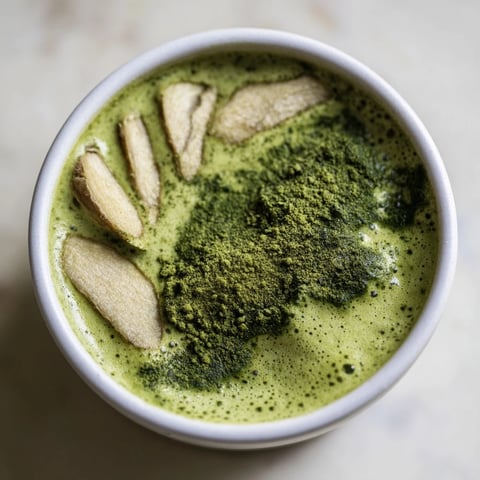 Steaming Coconut Ginger Matcha Winter Immunity Latte, a vibrant green, is perfect for a cozy winter evening.