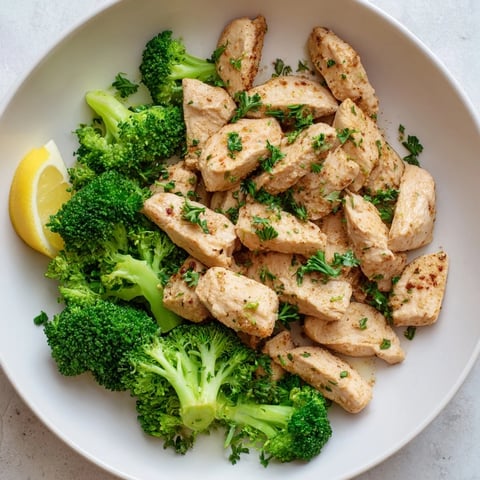 Tender Microwave-Steamed Chicken and Broccoli plated with parsley, a balanced, healthy main course.