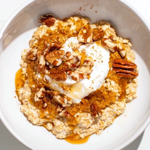 Steaming bowl of Pumpkin Spice Latte Oats, topped with whipped cream and cinnamon sprinkles, delicious.