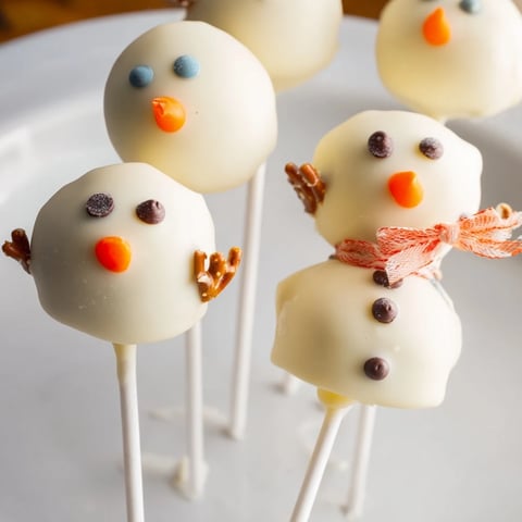 White chocolate-covered Oreo Snowman Cake Pops, adorable and ready for a winter holiday treat.