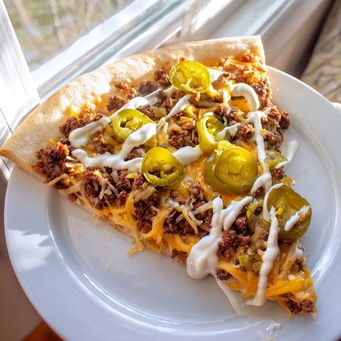 Ground beef taco pizza with melty cheese and jalapeños, ready to slice and enjoy.