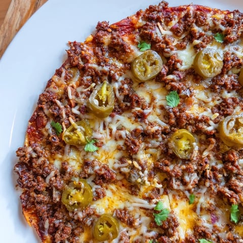 Spicy Ground Beef Pizza Base, fresh from the oven, with bubbling cheese and a sweet hot honey drizzle.