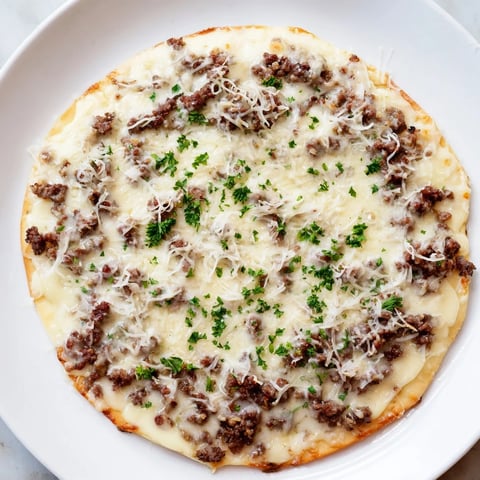 Ground Beef Alfredo Pizza, steaming hot, with bubbly mozzarella and a delicious creamy sauce.
