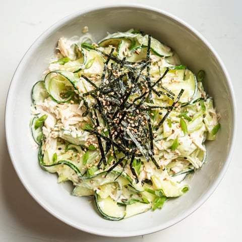 Crisp sliced cucumbers tossed with creamy mayo, imitation crab, and toasted sesame seeds in a California Roll Cucumber Salad.
