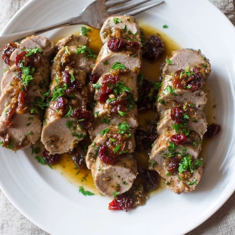 Close-up of juicy Cherry-Date Glazed Pork Tenderloin recipe: Sear marks and rich color.