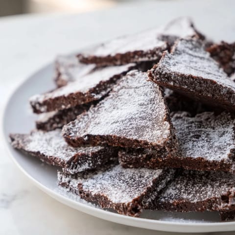 Warm, freshly-baked Chocolate Crinkle Cookies are pictured, perfect for holiday cookie trays.