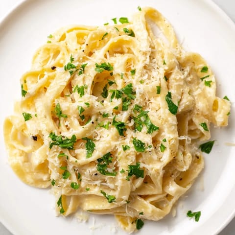 Hearty plate of Sriracha Honey Pasta with al dente noodles, sautéed garlic, and a drizzle of golden honey glaze.  