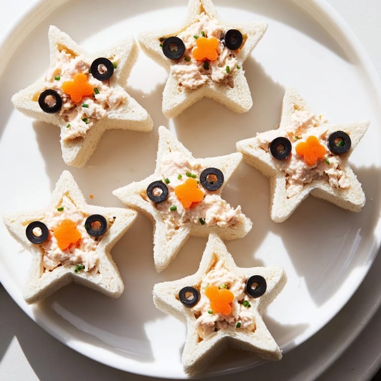 Close-up of vibrant Mini Starfish Sandwiches with tuna filling, olives, and capers, perfect for kids.