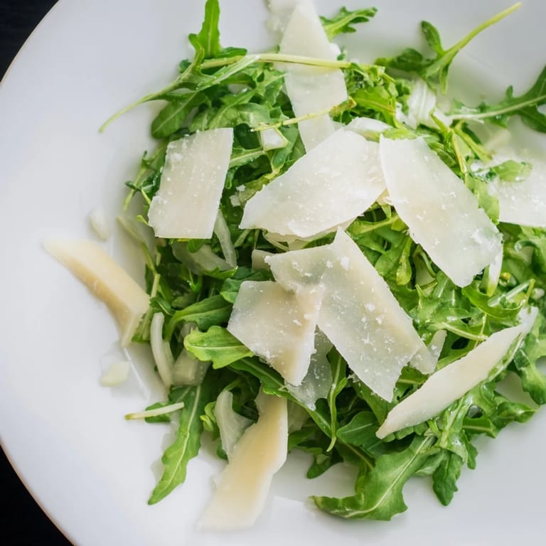 This Italian-inspired arugula salad recipe showcases vibrant green leaves with a tangy lemon dressing.