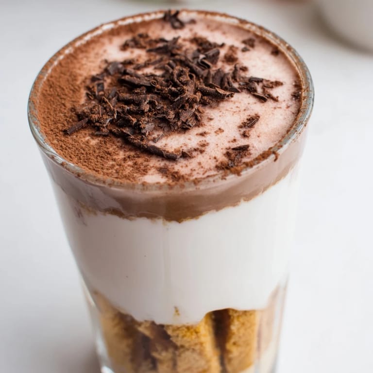 A beautiful close-up of a Tiramisu Latte, ready to drink, with visible coffee and mascarpone layers.