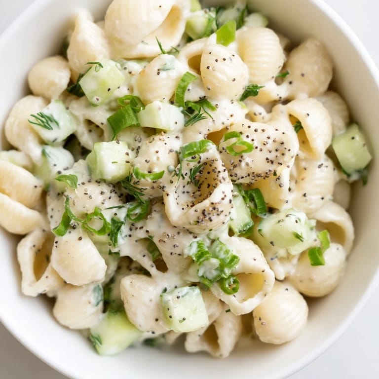 Overhead view of Cucumber Crunch Pasta Salad, a vegetarian side dish with tender pasta, crisp cucumbers, and herbs in a tangy, creamy dressing.