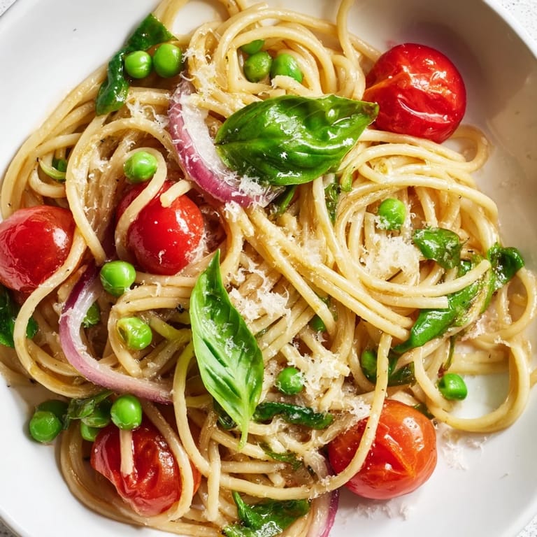 Close-up of Spring Veggie One-Pot Spaghetti, saucy and vibrant, topped with grated Parmesan and basil, perfect for a busy weeknight.