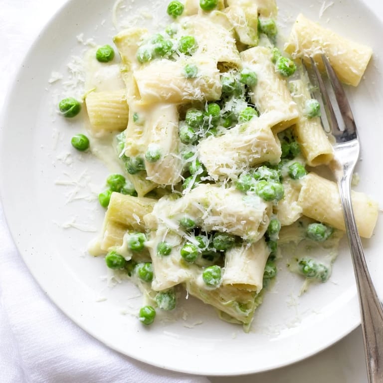 Savory Pea & Lemon Ricotta Pasta served warm with extra lemon zest and a fork ready to twirl al dente noodles.
