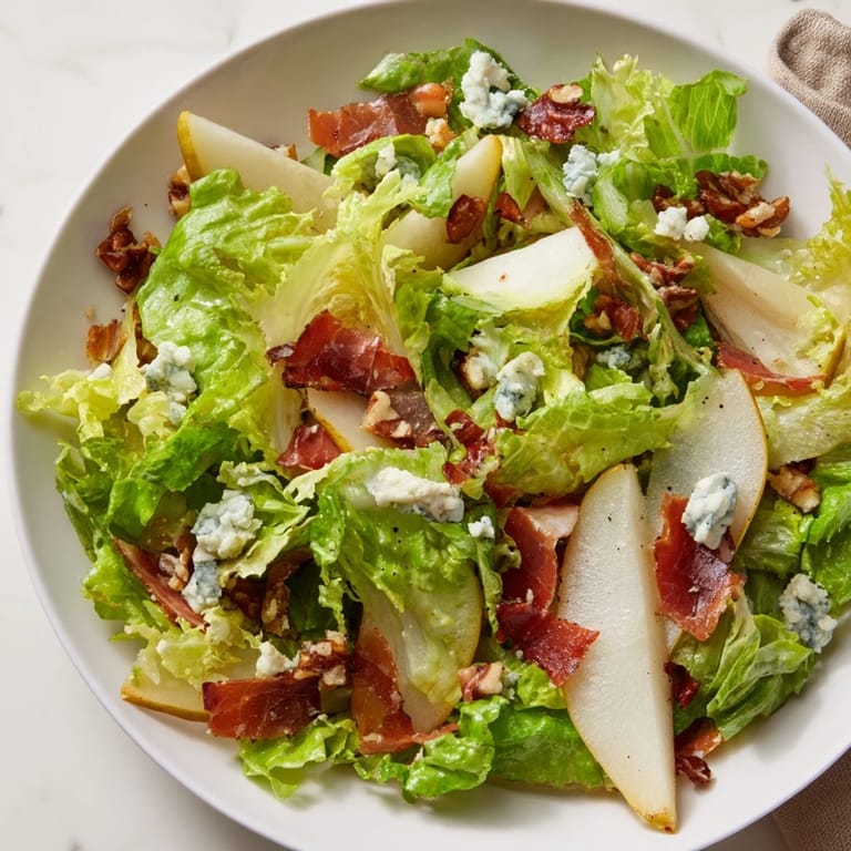This elegant frisée, pear, and blue cheese salad with crispy prosciutto is a perfect light lunch.