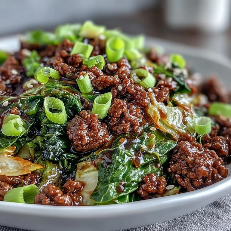Freshly plated Chinese Ground Beef and Cabbage Stir-Fry topped with sliced green onions, ready for a low-carb dinner.