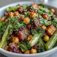 Crunchy celery peanut salad with soy ginger dressing in a white bowl, garnished with sesame seeds and fresh cilantro.  
