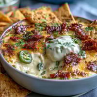 Cinco de Mayo Loaded Queso Dip with spicy chorizo, pico de gallo, and melted cheese, served with crunchy tortilla chips.