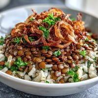 Levantine Mujadara piled high with fluffy grains and golden crispy onions.